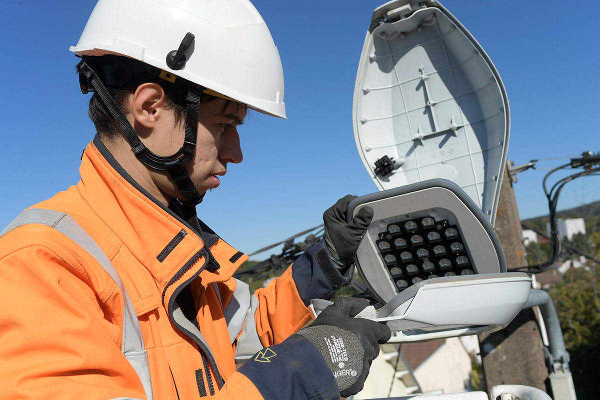 un agent changeant une ampoule d'éclairage public