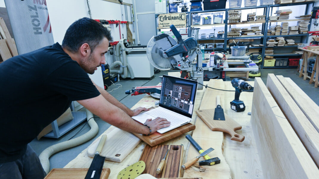 AGENT-ç, bois et convivialité François Gilabert travaillant sur son ordinateur dans son atelier